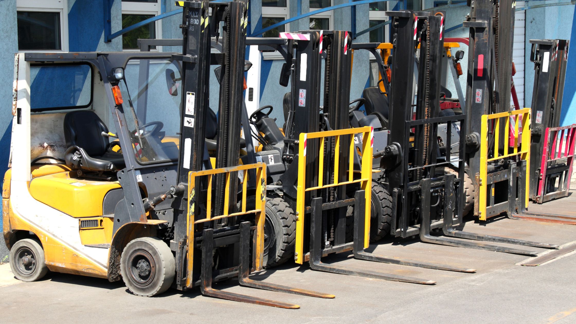 Several forklifts lined up next to each other.